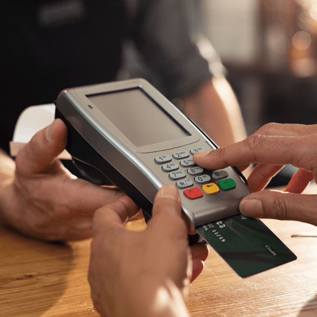 A customer types in their PIN to their credit card on a terminal at a checkout