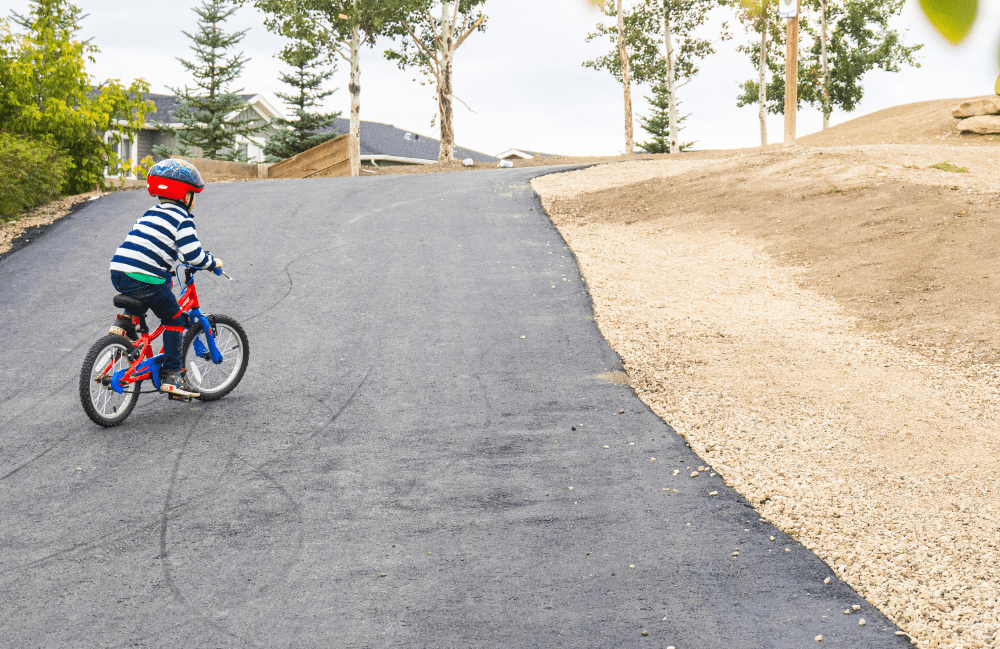 A young biker makes his way up a small hill in the bike park